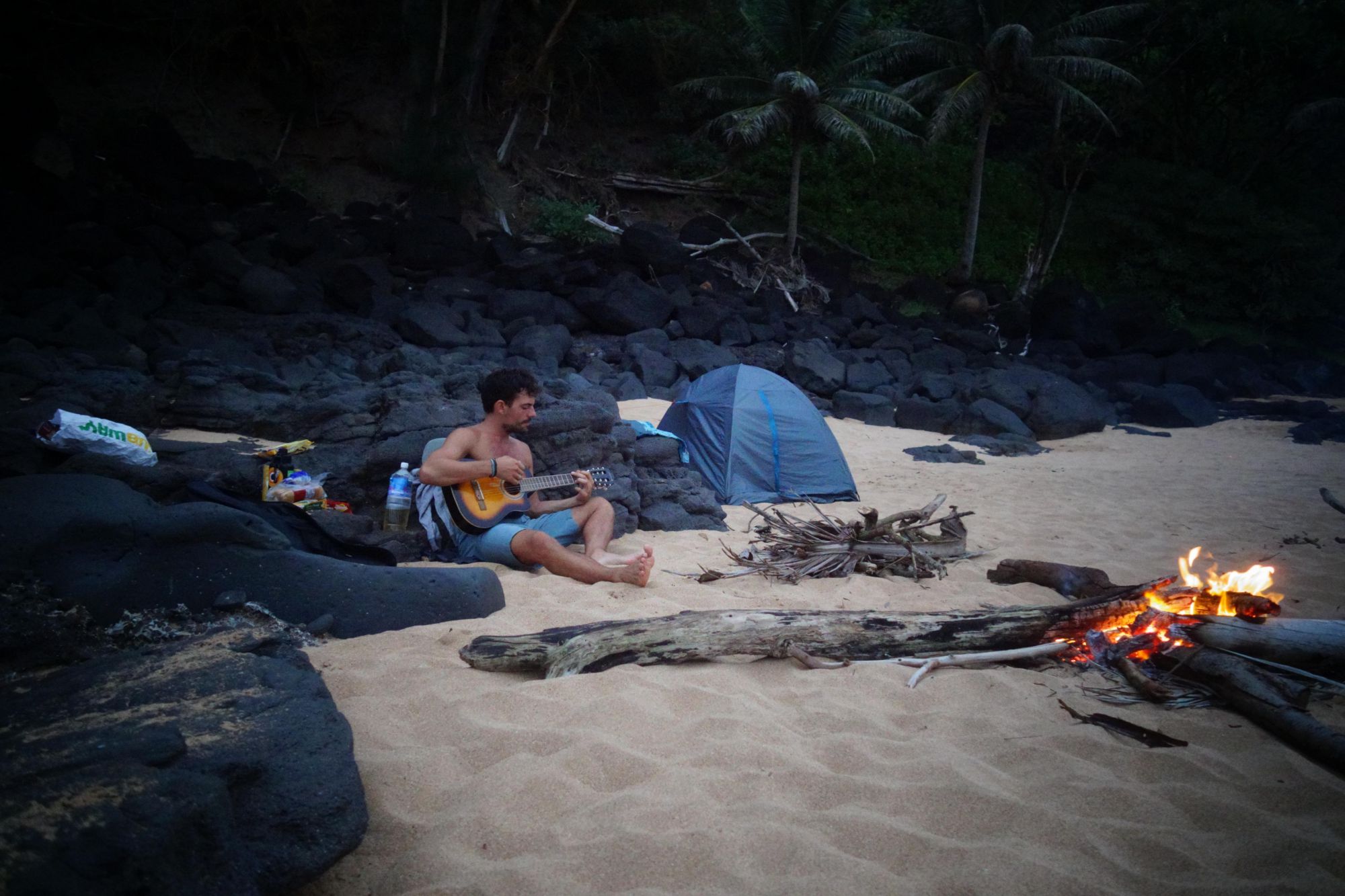 playing the guitar at secret beach Kauai campfire